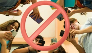 Группа польских школьников держит смартфоны под знаком запрета