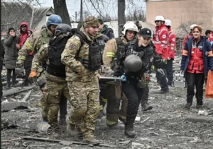 Рятувальники та патрульні евакуюють пораненого на носилках після удару по Запоріжжю
