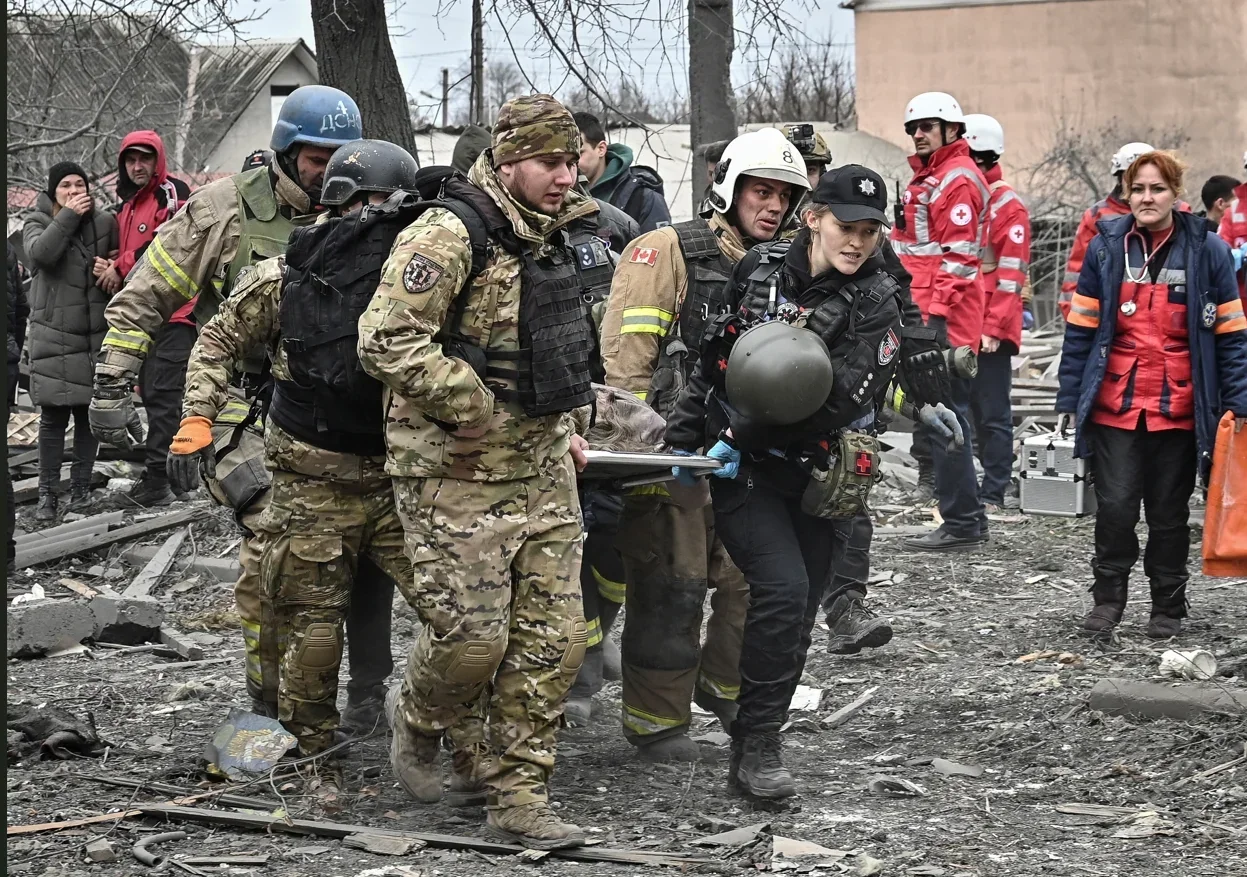 Рятувальники та патрульні евакуюють пораненого на носилках після удару по Запоріжжю