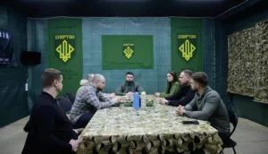 Бійці бригади «Спартан» зі співаком Drevo за столом з прапорами підрозділу