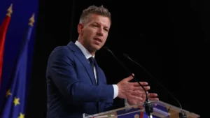 Петер Мадьяр подводит итоги переговоров с Еврокомиссией за трибуной с флагами ЕС и Венгрии