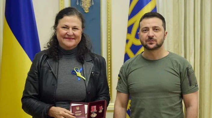Посол ЕС Катарина Матернова с президентом Зеленским держит паспорт и медали на фоне флагов Украины