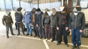 Украинские гражданские в плену со скрытыми лицами возле автобуса