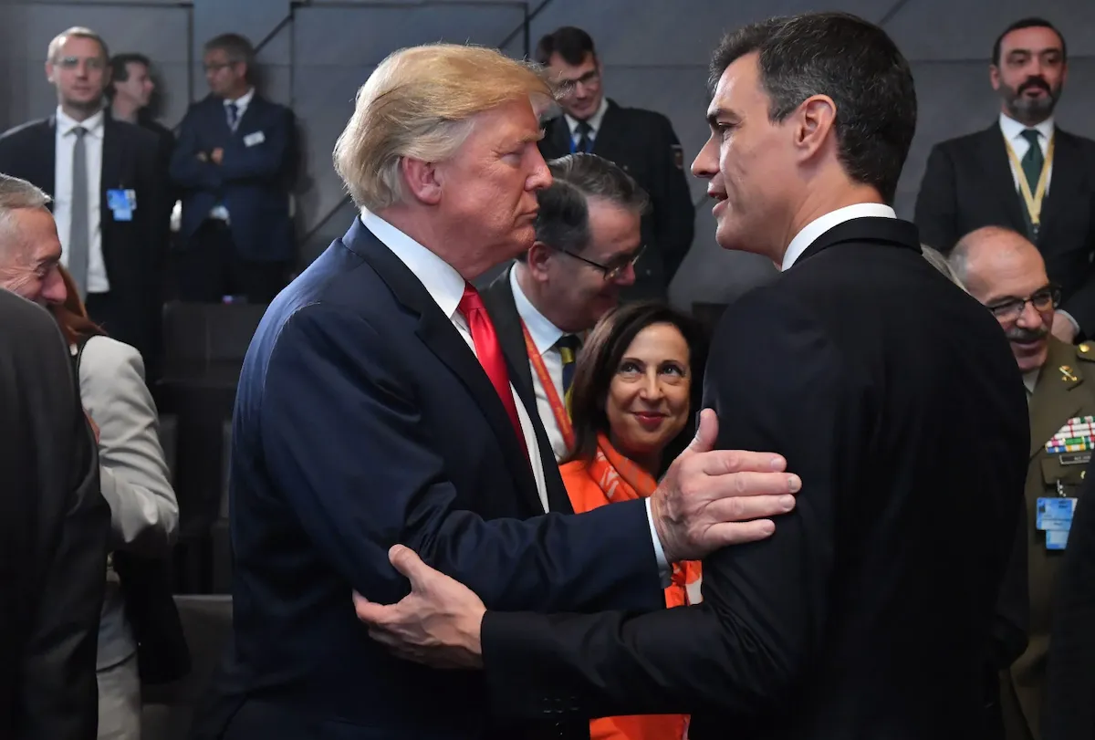 Дональд Трамп і Педро Санчес обіймаються на саміті НАТО щодо внесків у оборону