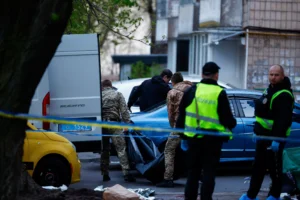 Поліцейські та військові біля фургона з тілом у мішку на вулиці Києва