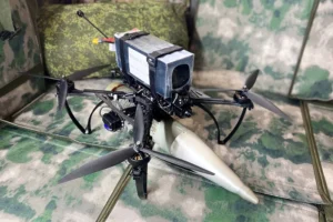 Чотиримоторний російський FPV-дрон з підвішеним боєприпасом на камуфляжній тканині