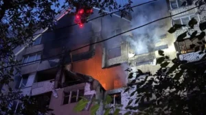 Ночной пожар с дымом и огнём в повреждённом многоэтажном жилом доме