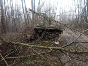 Військова вантажівка під гілками дерев у туманному лісі