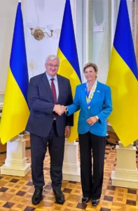 Андрій Сибіга і Байба Браже тиснуть руки перед українськими прапорами