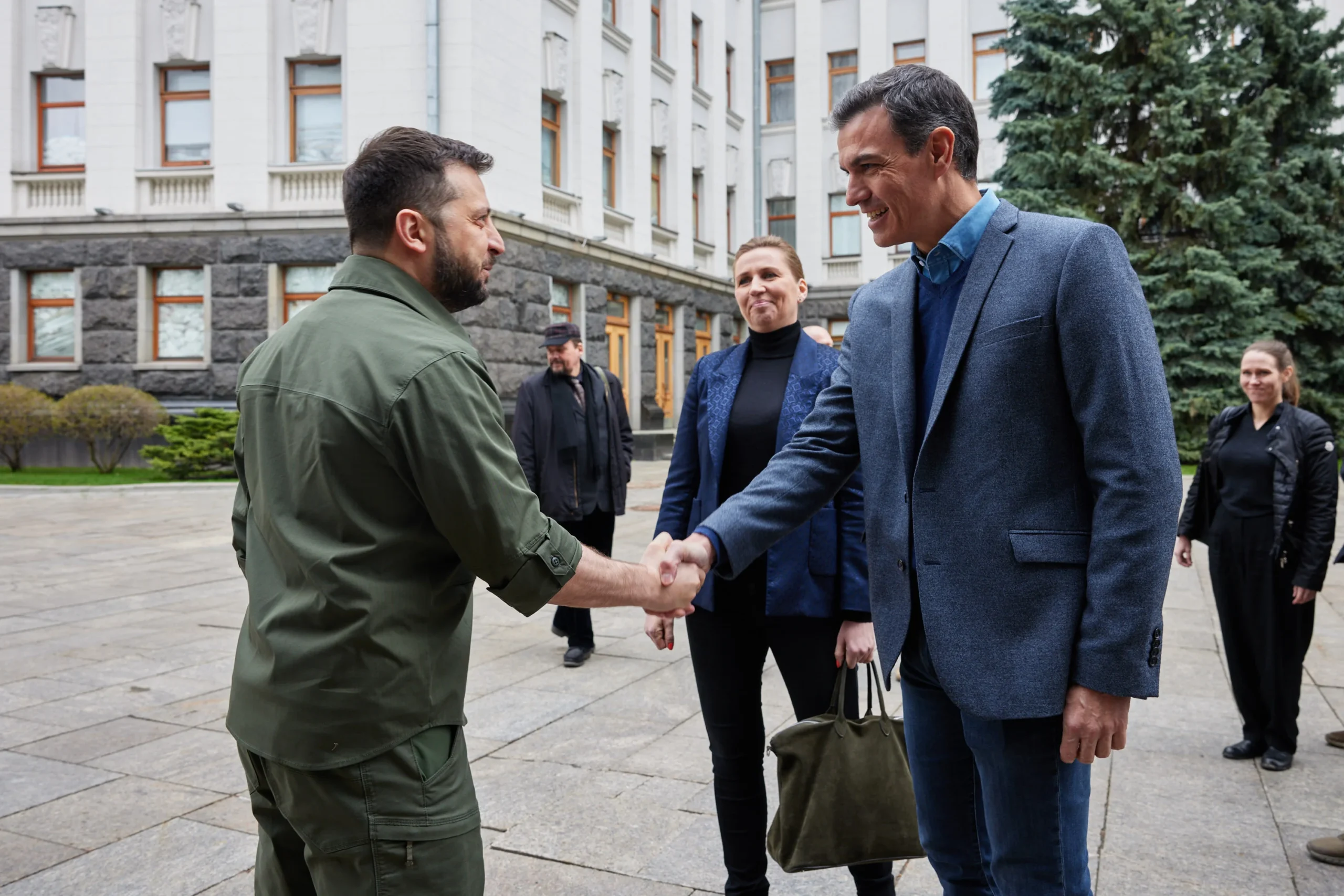 Зеленський тисне руку Санчесу, поруч Фредеріксен біля будівлі у Києві