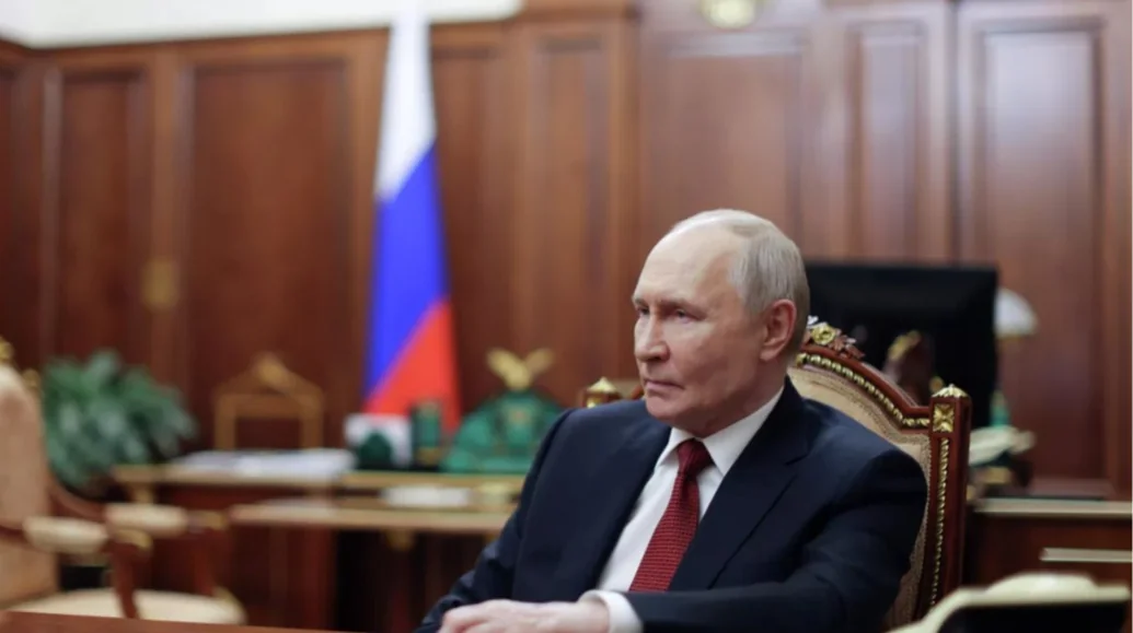 Володимир Путін сидить у кабінеті біля російського прапора