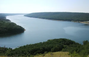 Панорама большого водохранилища на Днестре с густыми зелёными лесами на берегах