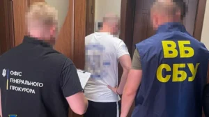 Сотрудники Офиса генпрокурора и ВБ СБУ с мужчиной в белой футболке у дверей