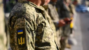 Військовослужбовці ЗСУ в камуфляжі з нашивками прапора та тризуба стоять у шерензі